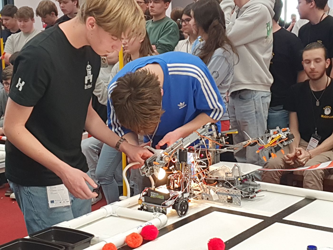 Students making a last-minute adjustment to their autonomous robot during an ECER match