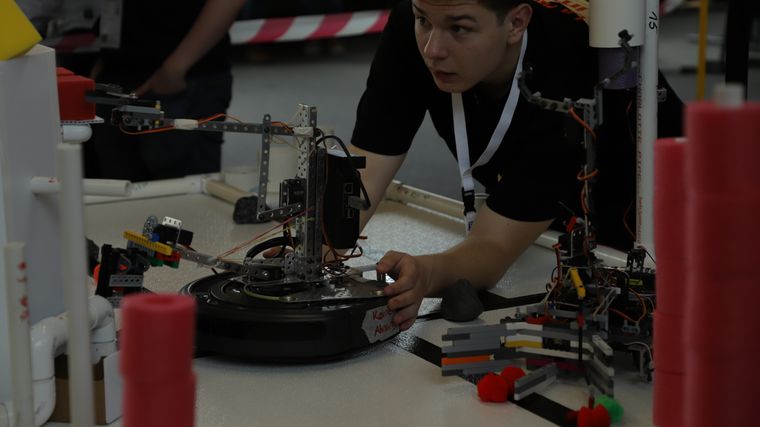 A student working closely on their robot